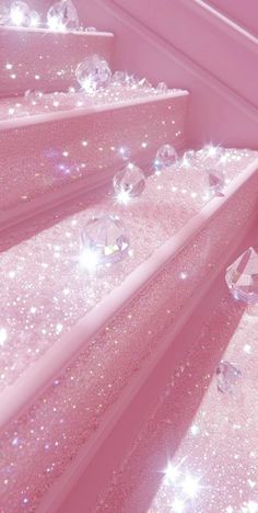 the stairs are covered with sparkling diamonds and sparkles in pink hued lighting, as well as shiny glass balls on them