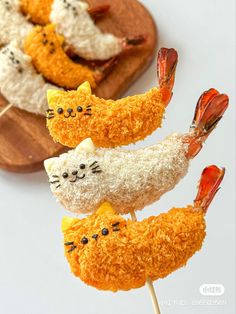 some kind of food that looks like cats on skewers with rice and other toppings