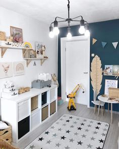 a child's room with blue walls and white furniture