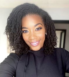 a woman with curly hair wearing a black top