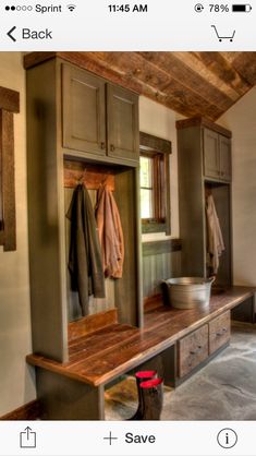 a wooden bench sitting inside of a room next to a wall mounted coat dryer