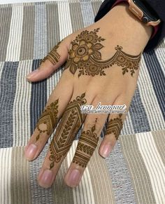 a woman's hand with henna tattoos on it