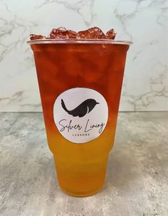 a cup filled with liquid sitting on top of a counter next to a marble wall