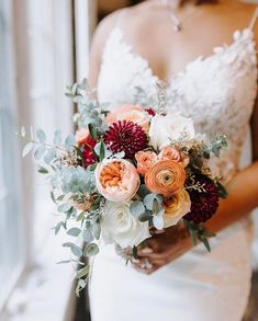 a bride holding a bouquet of flowers in her hand