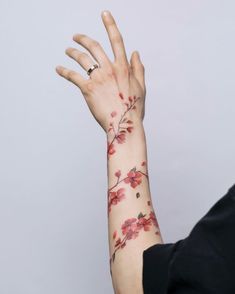 a woman's arm with red flowers on it