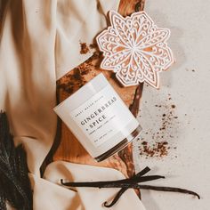 a candle and some cinnamon sticks on a wooden cutting board with an ornament