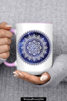 a woman holding a coffee mug with a blue and white flower design on the front