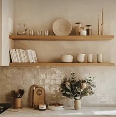 the shelves above the kitchen sink are filled with dishes and vases on top of them