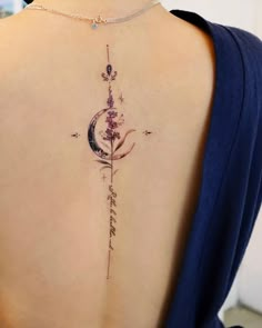 the back of a woman's neck with a flower and moon tattoo on it