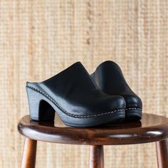 The Lisa high heeled clog is one of our all-time favourites. This classic clog in soft black leather is the perfect addition to your wardrobe this season. With its cushioned, flexible sole, it is both chic and easy to wear. The Lisa clog is designed in Sweden and handmade in Italy. Heel 7.5 cm / 2.95 in Soft, flexible lightweight sole Normal fit Classic Black Clogs With Reinforced Heel, Classic High Heel Leather Clogs, Comfortable Leather Clogs With Wooden Heel, Leather High Heel Clogs With Rubber Sole, High Heel Leather Clogs With Rubber Sole, Classic Clogs With Reinforced Heel, Black Leather Footbed Clogs, Classic Leather Clogs With Wooden Heel, Black High Heel Clogs With Leather Sole