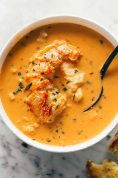 a white bowl filled with soup and some bread