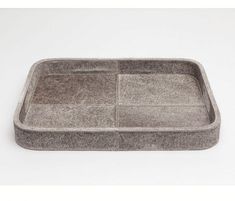 a gray tray with two compartments on the bottom and one in the middle, sitting on a white surface