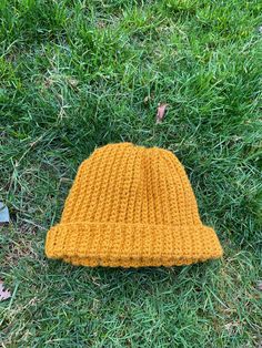 a yellow knitted hat laying on the grass