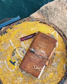 an old book and pair of scissors sitting on a rock