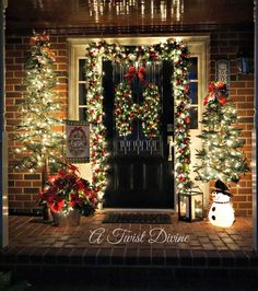 the front door is decorated with christmas lights and garlands for holiday decorations, including pine trees