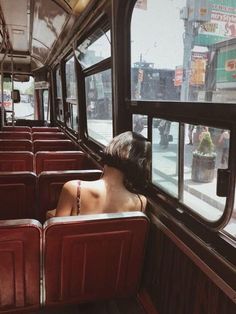 a woman sitting on a bus looking out the window