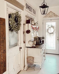 an old fashioned kitchen with white walls and wood flooring is decorated with wreaths