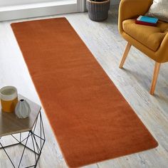 an orange rug is in the middle of a living room