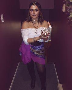 a woman dressed in costume holding a donut