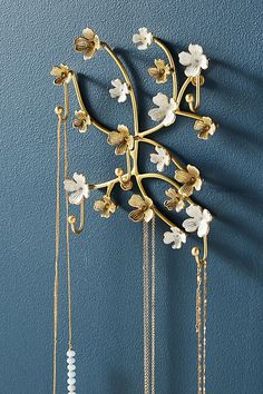 a gold and white chandelier hanging from the side of a blue painted wall