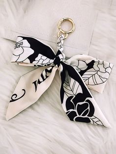 a black and white bow keychain on top of a white furnishing