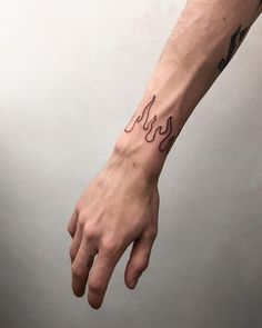 a person's hand with a small tattoo on the left wrist and right arm