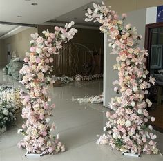 an arch made out of flowers in the middle of a room