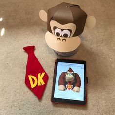 there is a stuffed monkey next to an ipad and a dr seuss necktie