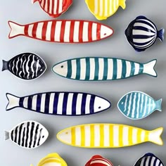 colorful fish are arranged in rows on a gray surface with white and black stripes,