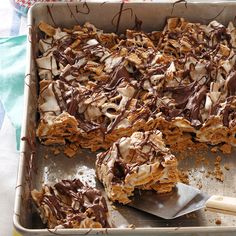 a pan filled with chocolate dessert next to a spatula