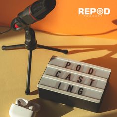 a microphone and some type of lightbox on a table next to a sign that says podd cast ing