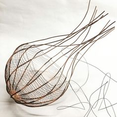 a wire sculpture sitting on top of a white surface