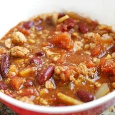 a close up of a bowl of chili with meat and beans on the side,