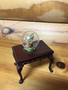 a glass ball sitting on top of a wooden table