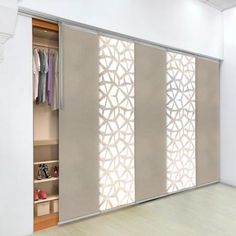 an open closet with sliding doors and clothes on hangers