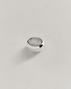 a silver ring sitting on top of a white surface