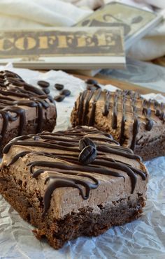 three pieces of chocolate cake on top of wax paper with coffee sign in the background