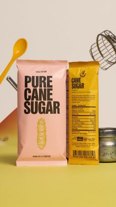 two bags of pure cane sugar next to a cookie scooper on a yellow table