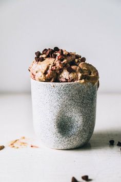 a bowl filled with food sitting on top of a white table next to some seeds