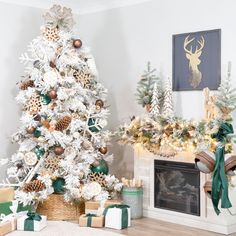 a white christmas tree with gold and green ornaments in front of a fireplace mantel