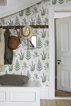 a coat rack with hats and purses hanging on the wall next to a door