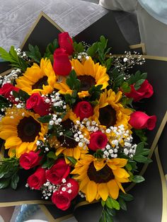 a bouquet of sunflowers and roses on a table