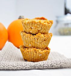 three muffins stacked on top of each other with an orange in the background