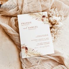 the wedding program was placed on top of a blanket with flowers and leaves around it