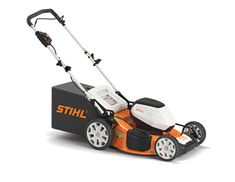 an orange and white lawn mower sitting on top of a black box with wheels