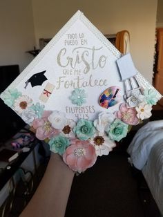 someone is holding up a graduation cap with flowers and writing on the front that says gratie or follale