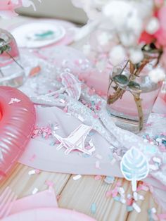 the table is set with pink and white confetti, balloons, and decorations