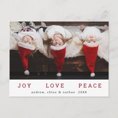 three children wearing christmas hats and red pants, with the words joy love peace above them