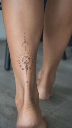 a woman's foot with an intricate tattoo on the side of her leg, in front of a chair