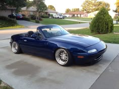 a blue sports car parked in front of a house